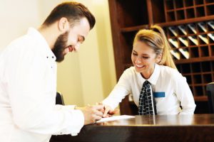 Picture of young businessman signing bill in hotel